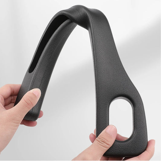 Black leather car seat handle held by a hand on a light gray background