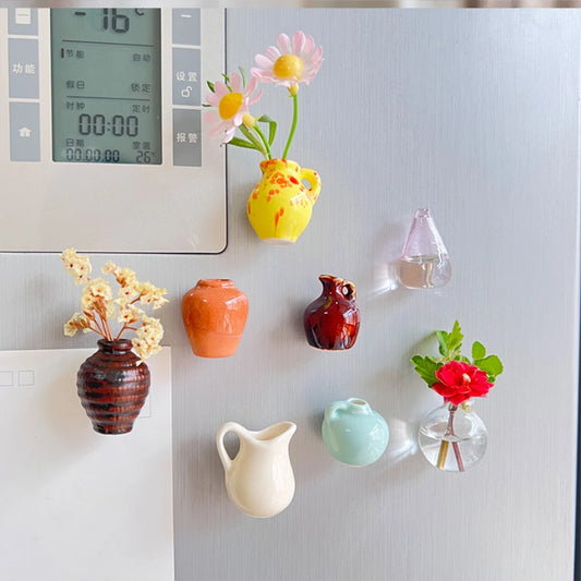 Colorful ceramic vases and flower decorations on a refrigerator.