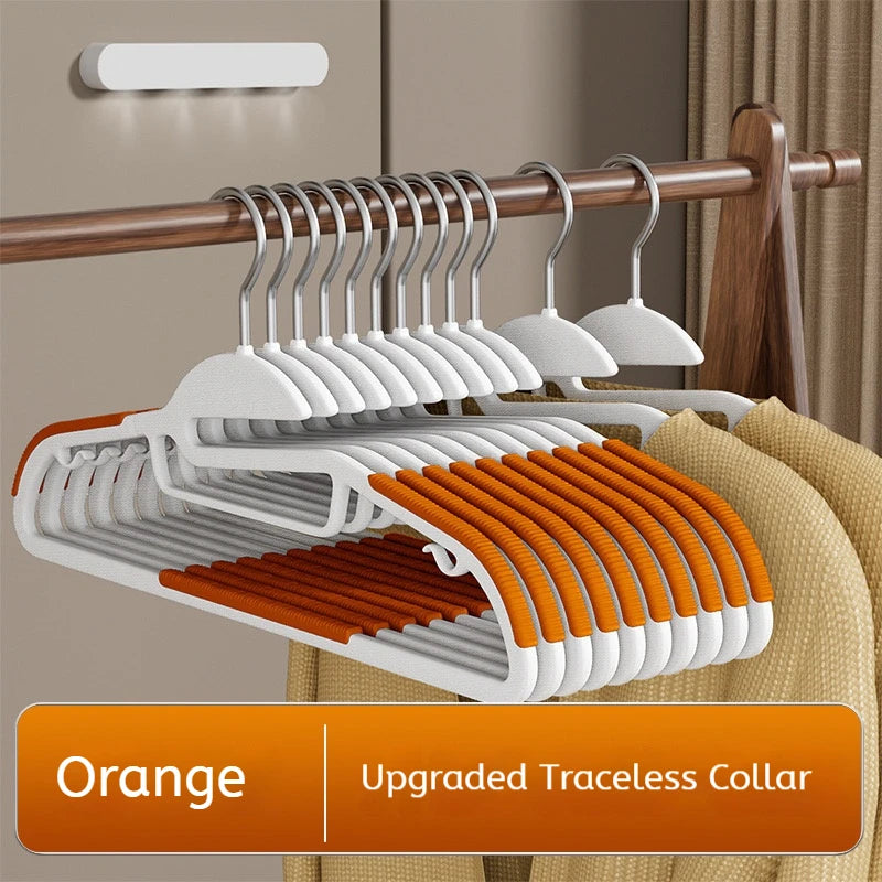 Set of orange and white hangers with an upgraded traceless collar on a wooden rack.