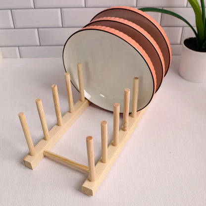 Wooden plate rack with plates on a white surface