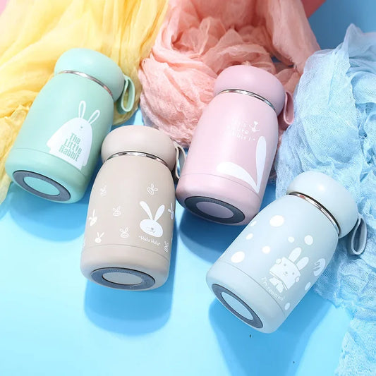 Four colorful thermos bottles with bunny designs on a blue background