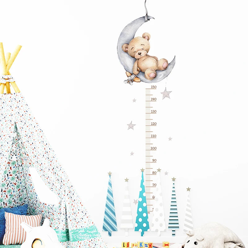 Children's room with teddy bear on a crescent moon, height chart, and Christmas-themed decor.