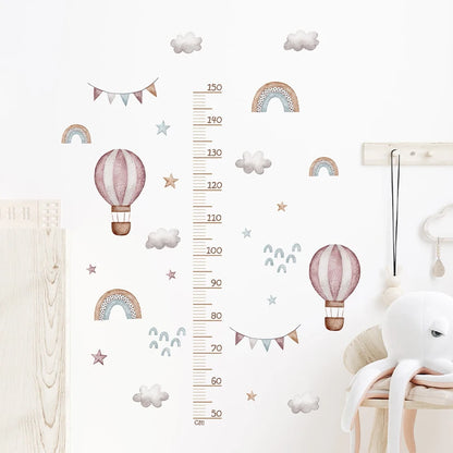 Children's room with wall decals including hot air balloons, rainbows, and a growth chart.