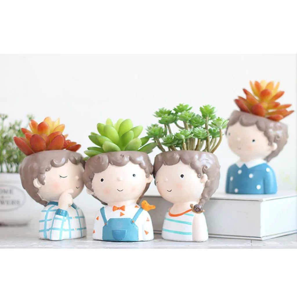 Set of four decorative planters shaped like children with succulents on a white background