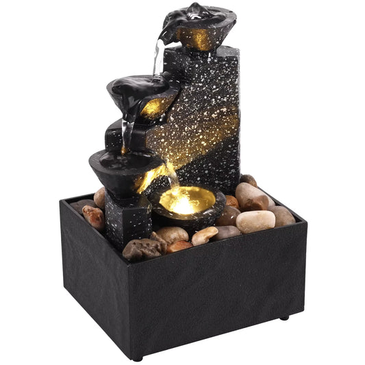 Black and gold tiered fountain with rocks on a white background